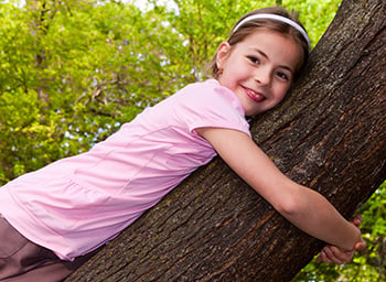 young girl sitting in a tree